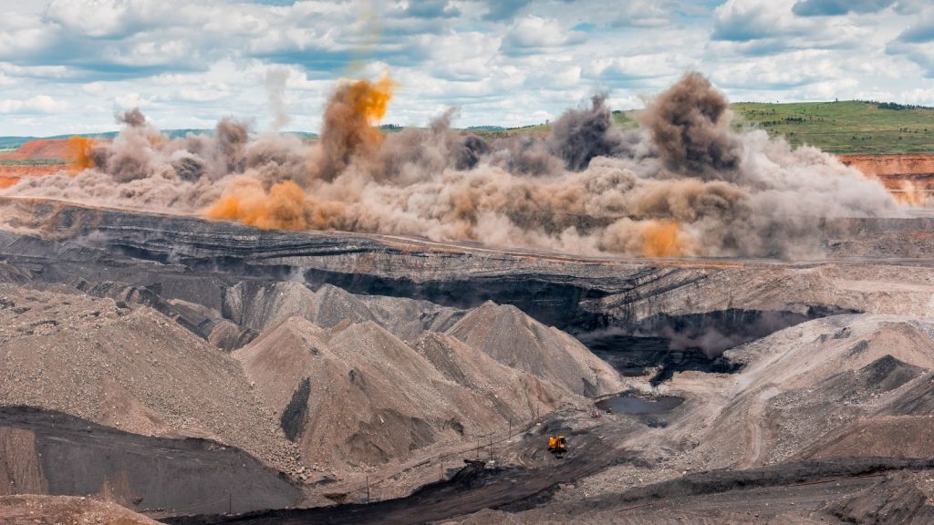 orange cloud rising from blast site on coal strip mine